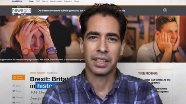 A man addresses the camera with a serious expression, seated in front of a computer monitor displaying a news website. The website features various news headlines and images of individuals reacting emotionally to news events. Opens a new window with the video.
