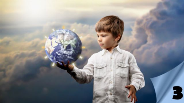 A young boy with light brown hair in a white shirt gently holds a globe in his left hand, his expression thoughtful. The background features dramatic clouds and soft lighting, creating an ethereal atmosphere. The number three is partially visible in the lower right corner, partially covered by a corner of the image. Opens a new window with the video.