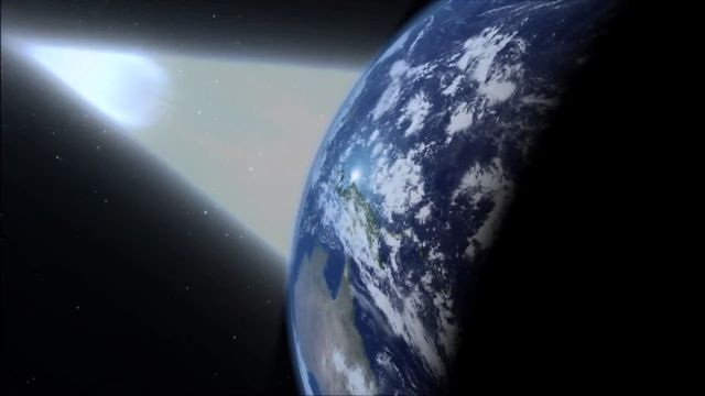 A digital depiction of Earth from space, showing the planet partially illuminated by sunlight against a backdrop of stars, with a bright comet passing in the near distance. Opens a new window with the video.