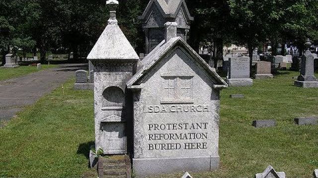 A pair of ornate, small stone mausoleum structures in a cemetery, one marked &ldquo;SDA Church&rdquo; and the other labeled &ldquo;Protestant Reformation Buried Here.&rdquo; Surrounded by numerous other gravestones under a clear sky. Opens a new window with the video.