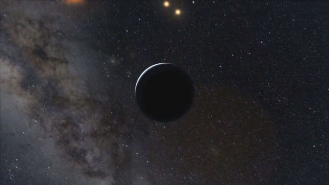 A celestial body with a dark silhouette passes before a dense field of stars and a nebula, illustrating the vast mysteries of the universe. Opens a new window with the video.
