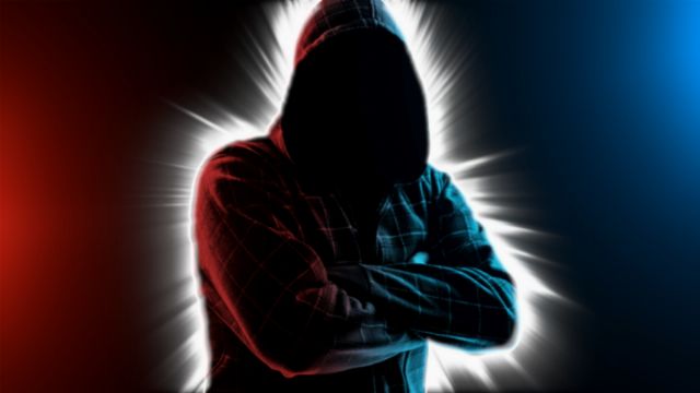 Silhouette of a person in a hooded shirt, arms crossed, enveloped in a dramatic interplay of red and blue light radiating outward reminiscent of celestial phenomena. Opens a new window with the video.