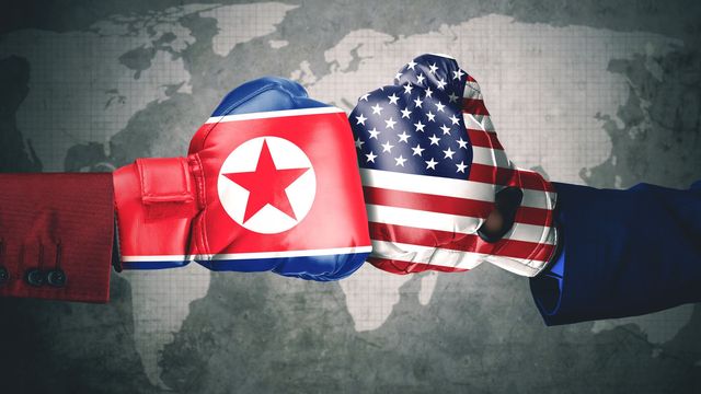 Two boxing gloves striking each other, one colored with the North Korean flag and the other with the American flag, set against a faded global map background. Opens a new window with the video.