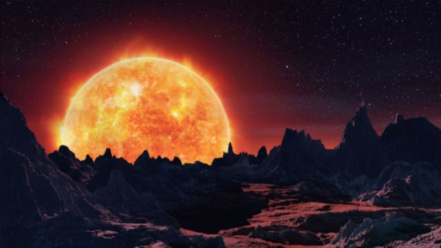 An expansive view of a rugged alien landscape under a star-studded sky, dominated by a large, radiant sun setting or rising over sharp mountain peaks. Opens a new window with the video.