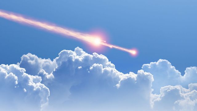 A celestial body streaks across the sky above fluffy cumulus clouds, glowing with intense warmth and surrounded by a vast expanse of blue. Opens a new window with the video.