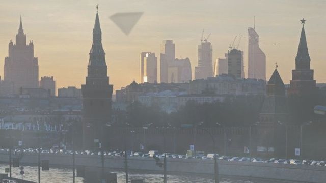 A city skyline at dawn, highlighting contrasting architectural styles with historic spires and modern skyscrapers backlit by the sun. Opens a new window with the video.