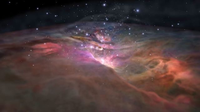 A vibrant depiction of a celestial region with radiant colors of pink, purple, and orange across nebulous formations, set against a backdrop of distant stars in the cosmos. Opens a new window with the video.