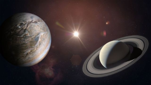 A digital illustration of a celestial scene featuring Earth and Saturn orbiting in space with the sun emitting a bright flare in the background. Nebulae and distant stars enhance the cosmic setting. Opens a new window with the video.